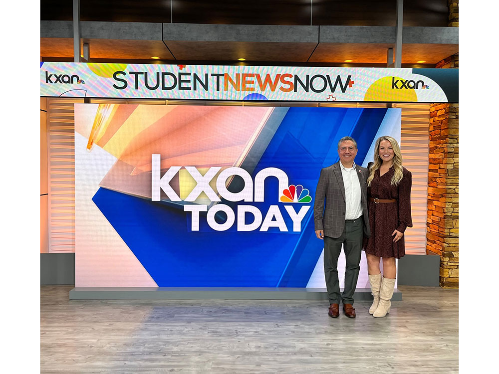 Javier Valdez stands next to a news woman on set at KXAN News.