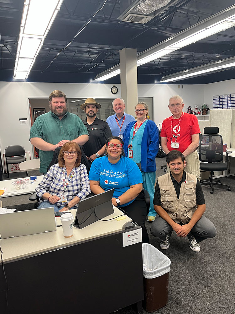 Group picture of Red Cross staff members, Nick Richardson and other volunteers in an office.