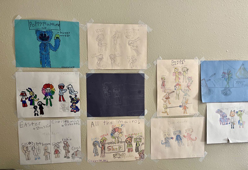 children drawings hanging on a wall.