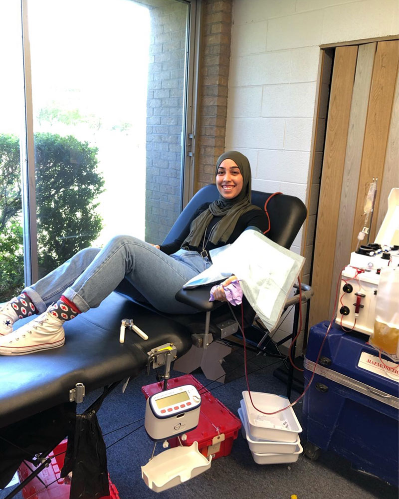 Reihaneh Hajibeigi sitting in chair while donating blood.