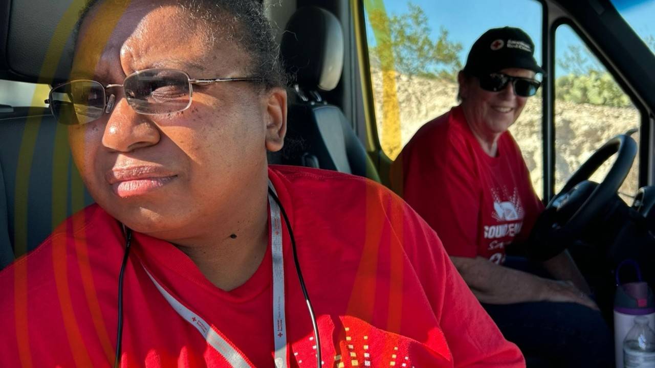 two red cross volunteers in vehicle