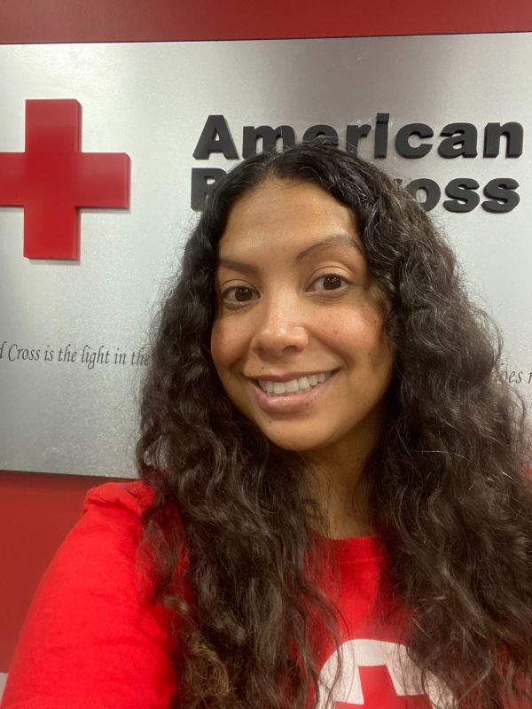 volunteer sandra in front of red cross sign
