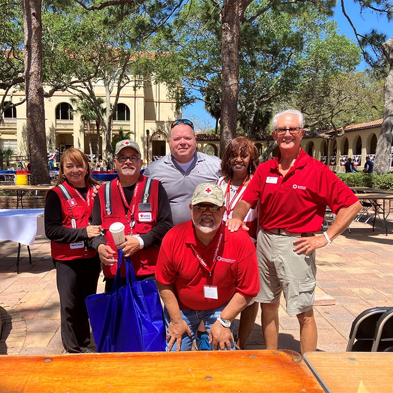 Red Cross volunteers and veterans smiling for camera.