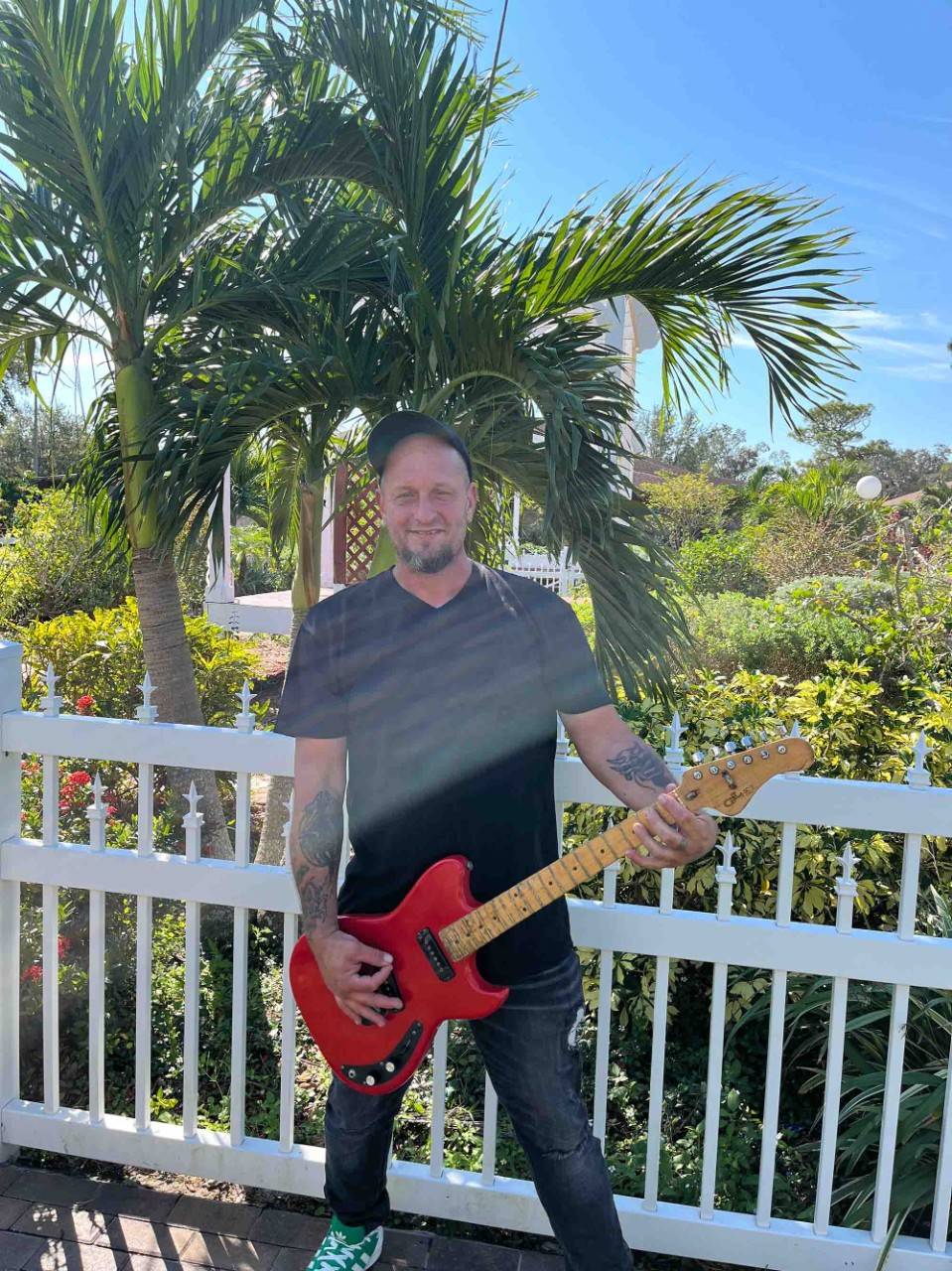 Adam Freed standng up and holding a guitar.