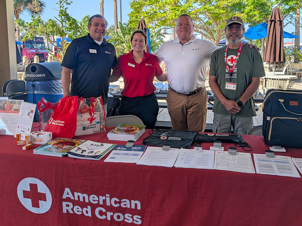 Red Cross workers at a table with Red Cross paperwork and items.