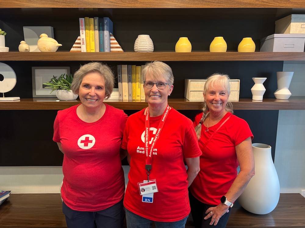 Three nurse volunteers in Red Cross tee shirts.