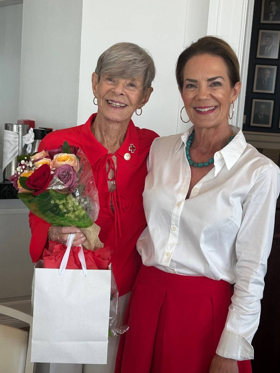 Outgoing President Joan Rhynewas presented with flowers by incoming president Leslie Jennewein