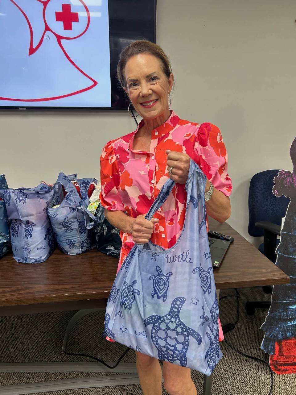 Leslie Jennewein, Red Cross Angels Incoming President, shows a stuffed reusable tote bag