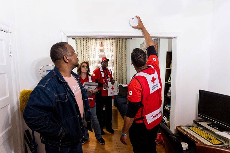 Red Cross volunteer installing smoke alarm