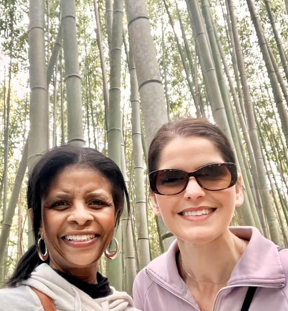 Janice Winston and Emily Fortman hiking with giant bamboo behind them.