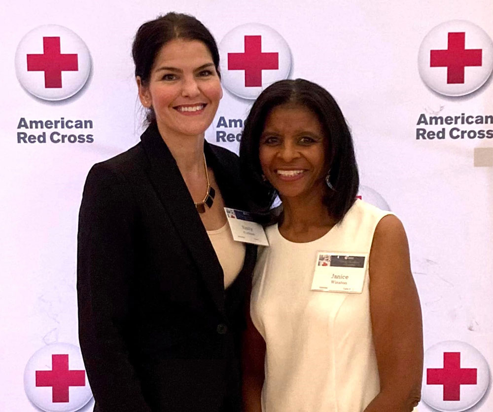 Janice Winston and Emily Fortman with Red Cross logos backdrop.