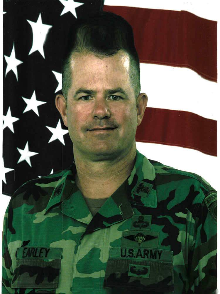 Jeff Earley military pic with an American flag in the background.