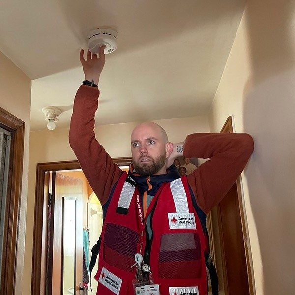 Red Cross volunteer installing a smoke alarm.