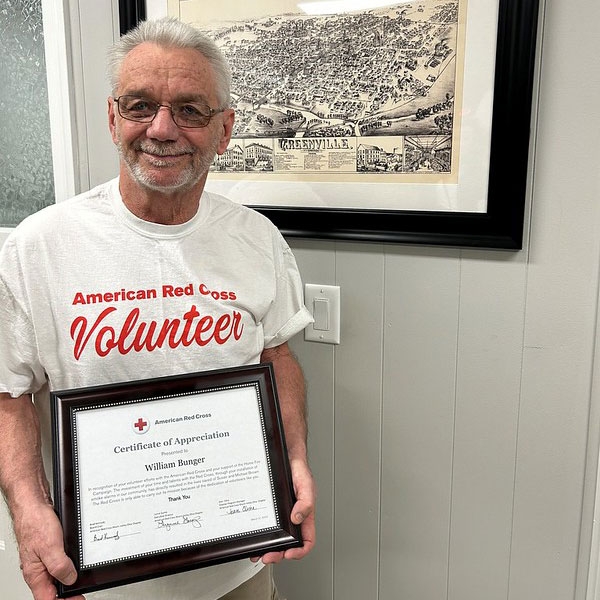 Volunteer William Bunger holding certificate.