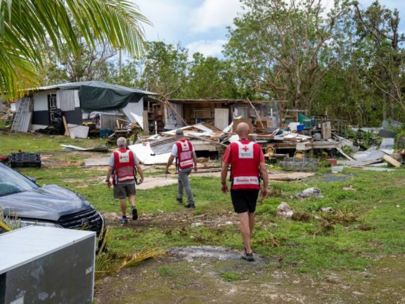 red cross volunteers walking through damaged area