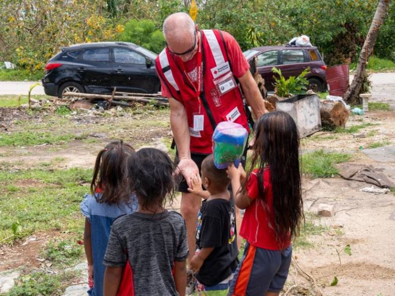 red cross disaster volunteer with children