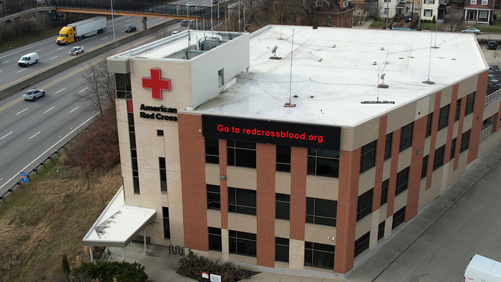 overhead shot of a red cross building next to a freeway.