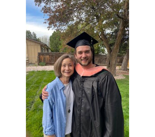 Benton Roesler, wearing a graduation gown and cap, standing next to his mom Pam.