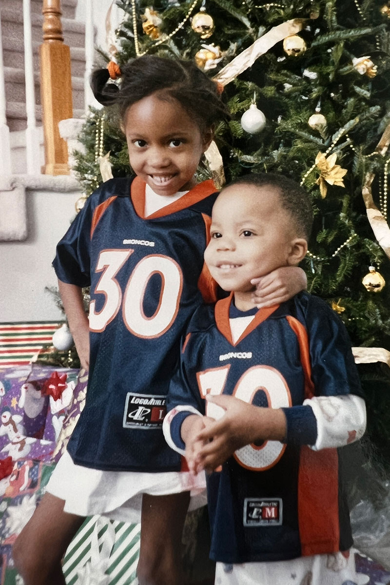Young Jasmine and Jordan Davis wearing NFL jerseys with Christmas tree in the background.