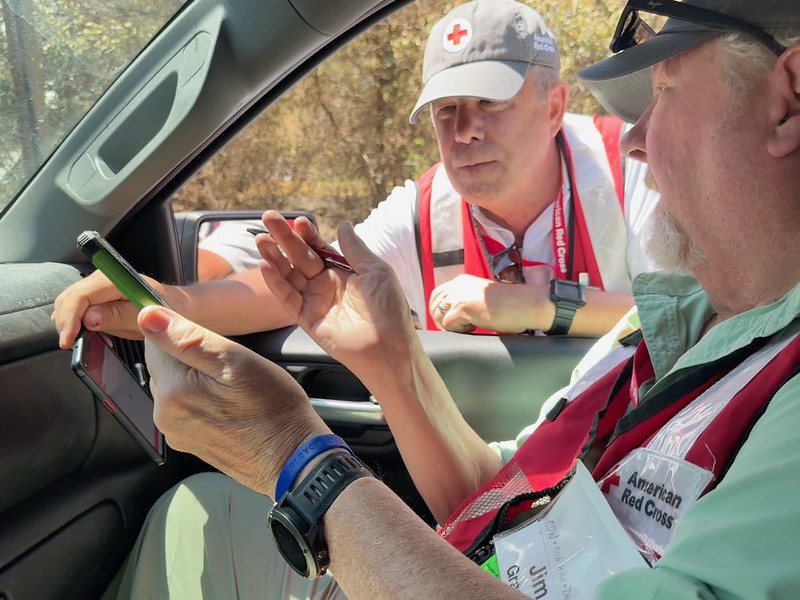 Two volunteers look at information on a phone