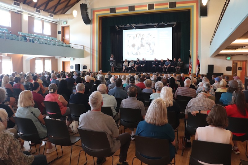 Group of people in an auditorium sitting and listening to a speaker