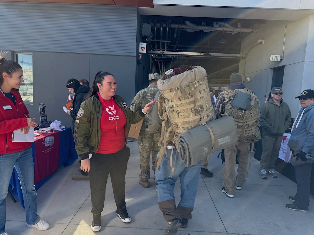 Red Cross volunteer stands with a homeless veteran