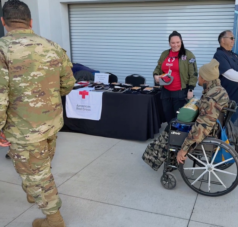 Red Cross volunteer stands with a homeless veteran