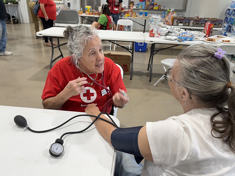 A woman takes another woman's blood pressure