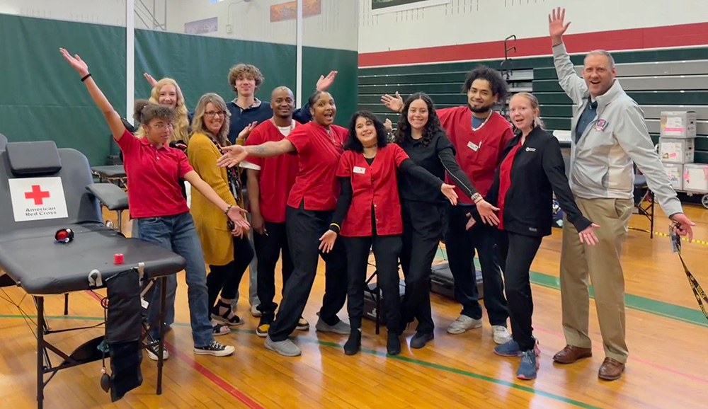 Red Cross volunteers, student club members and staff pose together
