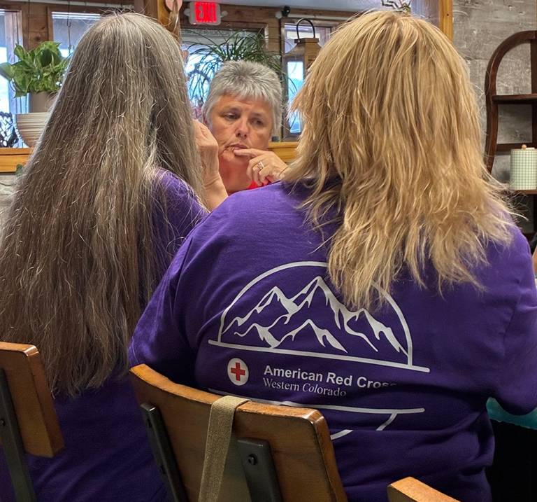 A woman listens as a volunteer talks during a conversation around a table