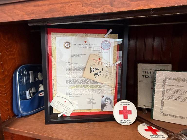 A shadow box of memorabilia inside of a cabinet