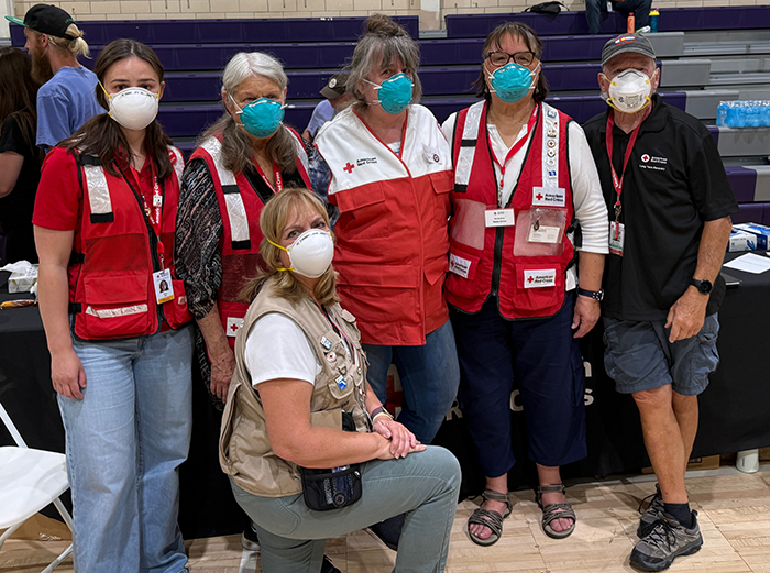 Group of Red Cross volunteers in protective equipment and respirators posed together