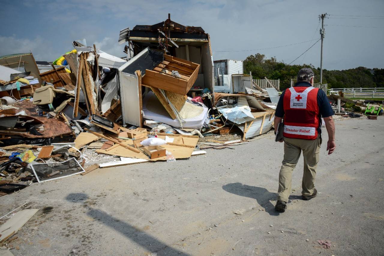 Emerald Isle, North Carolina, September 8, 2019. American Red Cross volunteer Bob Wallace inspects the disaster debris that just days before were cherished get-away homes at Boardwalk RV Park on Emerald Isle, North Carolina. The residents of the homes came to enjoy the ocean and their neighbors, many of whom had become close friends. A waterspout, traveling on the front edge of Hurricane Dorian, decimated a large number of homes in the park. Numerous residents said it was like a bomb had gone off.  Photo Credit: Daniel Cima/American Red Cross
