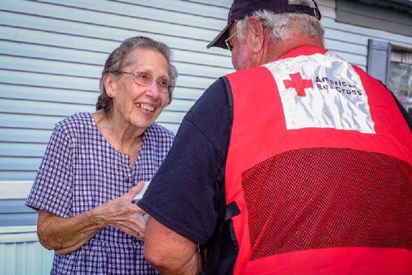 September 3, 2017. Victoria, Texas. Red Cross volunteer Ted Mueller of Norwood, Colorado, brings hot meals to Mabel Gaines. Mabel said,  The Red Cross is wonderful. God bless you.   
Photo by Chuck Haupt for the American Red Cross