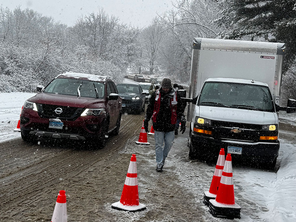 Red Cross volunteers directing traffic in the snow.