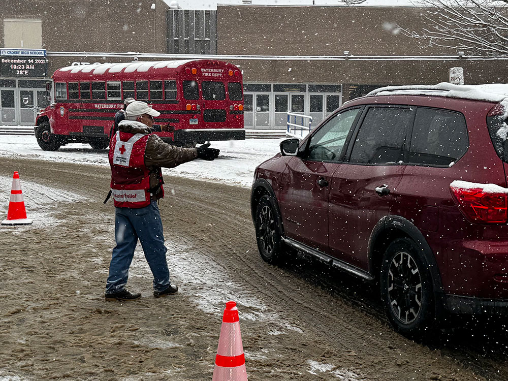 Red Cross volunteers directing traffic in the snow.