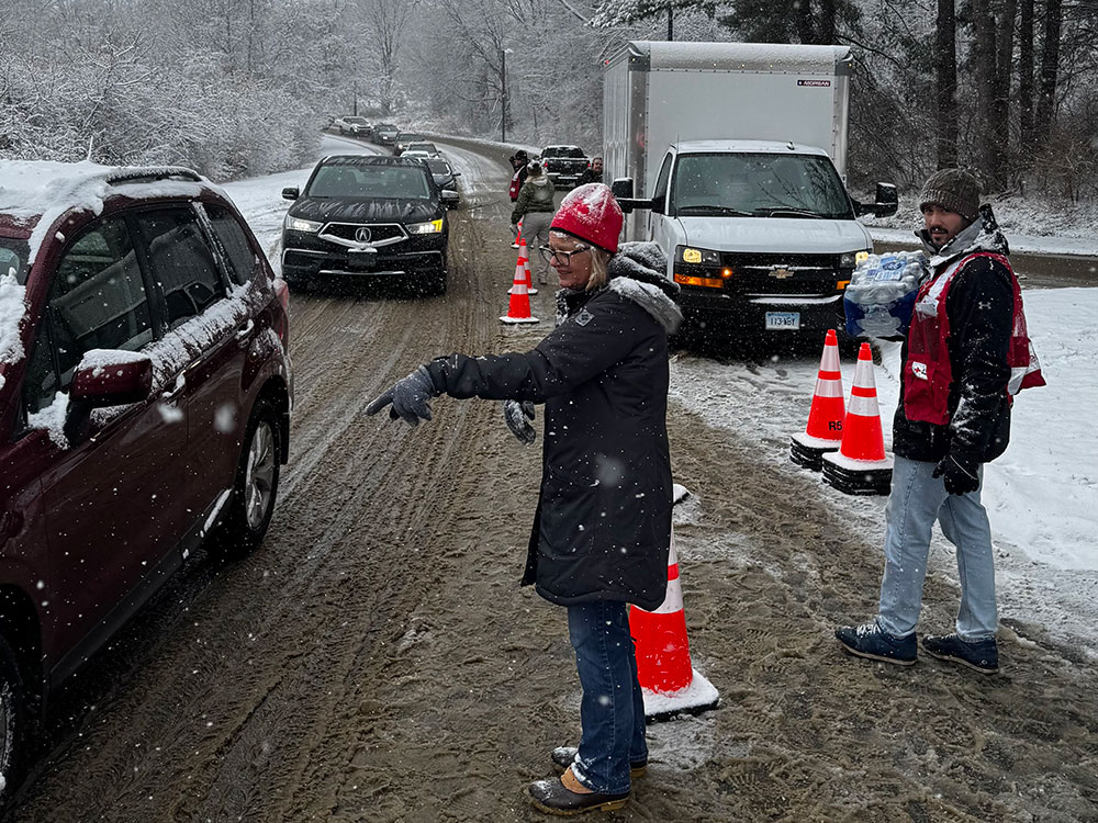 Red Cross volunteers directing traffic in the snow.