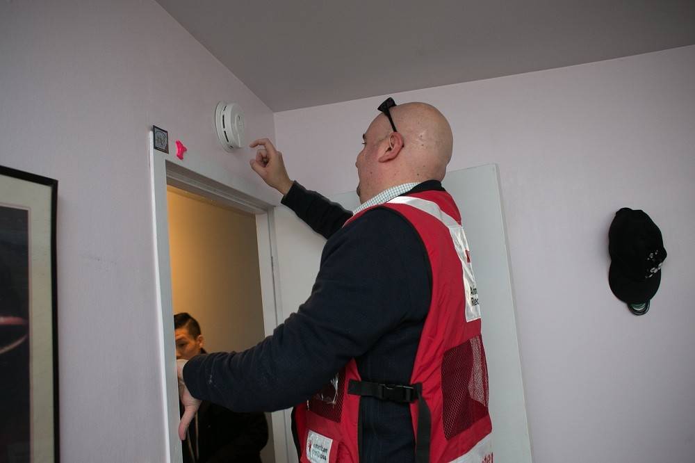 Monday, January 18, 2016. Alexandria, Virginia. In honor of Martin Luther King Jr. Day, thousands of volunteers across the country participated in a day of service by canvassing their local communities and installing smoke alarms for their neighbors. The National Capital Region of the American Red Cross hosted MLK Day of Service events supporting the Home Fire Campaign in communities throughout the National Capital Region. Red Cross volunteer, Christopher Klidi tests a newly installed smoke alarm.Photo by Dennis Drenner for the American Red Cross