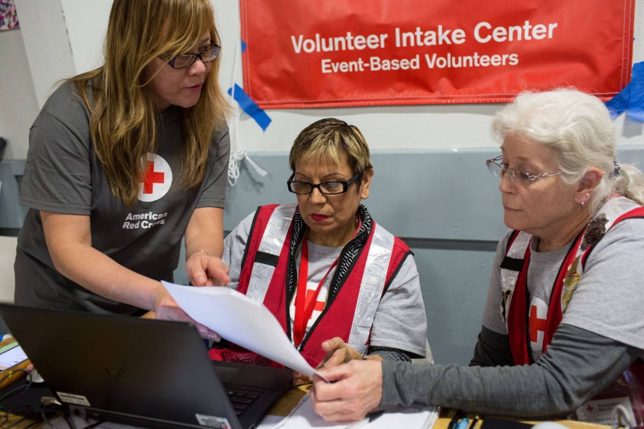 February 17, 2017. Chico, California.
Red Cross volunteers Eva, Anita and Diane manage the volunteer check-in desk at the Red Cross Oroville Dam evacuation shelter in Chico, CA. 
Photo by Marko Kokic for the American Red Cross