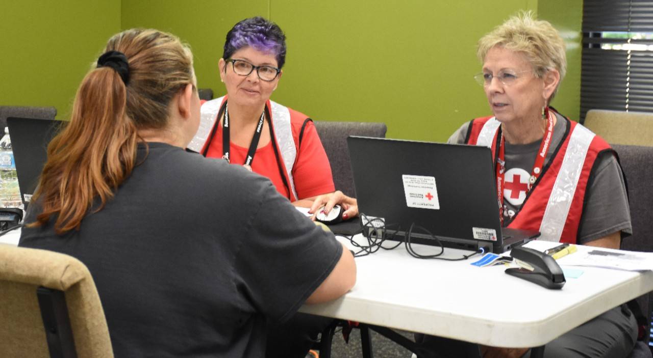 June 8, 2019. Fort Smith, Arkansas. American Red Cross caseworkers Joan Scott (right) and Madeleine Bonilla (left) meet with shelter resident Sarah Burris. Sarah said she was flooded out of her home in Moffett, Oklahoma, and found refuge in the Red Cross shelter in Fort Smith. Caseworkers such as Joan and Madeleine meet on an individual basis with people displaced by the floodwaters to help them develop a recovery plan and connect with recovery resources available from the Red Cross as well as many other community organizations.  Photo by Bob Wallace/The American Red Cross