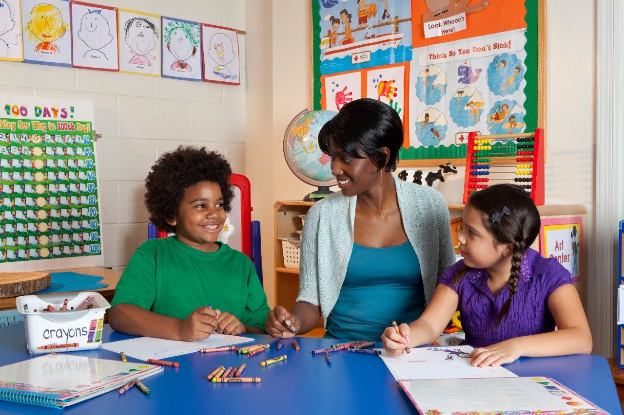 female teacher with two students in classroom