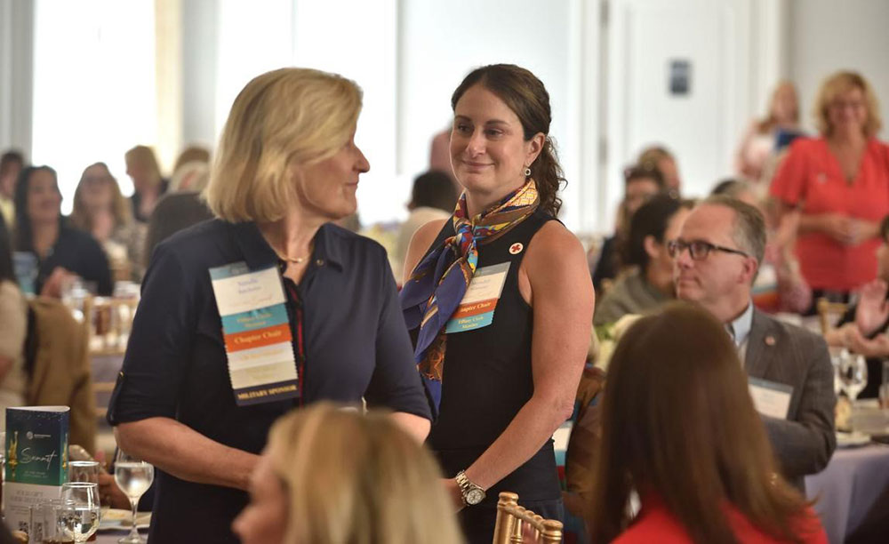 Two Tiffany Circle of Georgia members, Natalie Batchelor and Meredith Sidewater, standing up to pledge above and beyond their Tiffany Circle commitment to support families receiving disaster financial assistance.