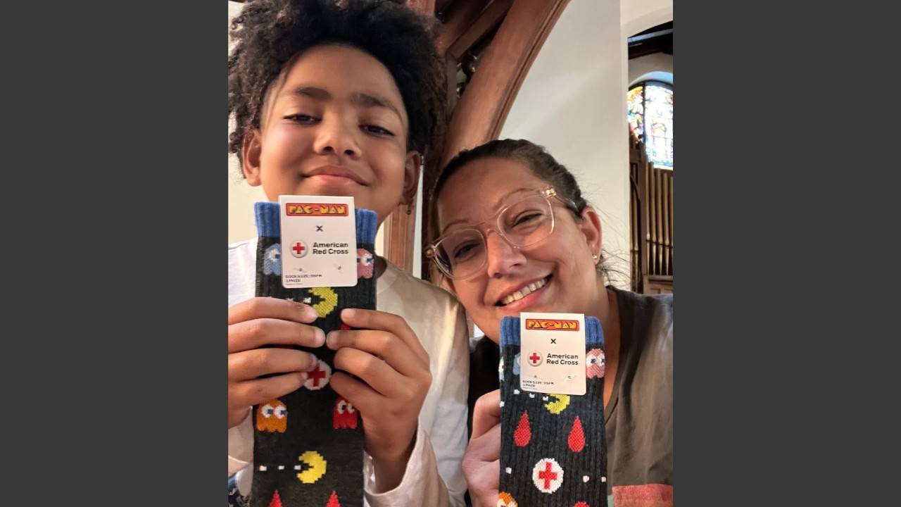 mother and son holding red cross socks