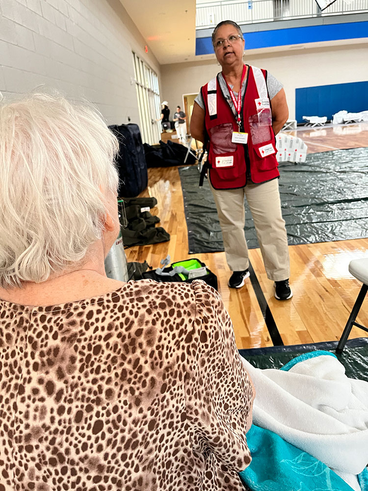 Red Cross volunteer Allean Harrington provides comfort and hope to Peggy Mohr at a Red Cross shelter.
