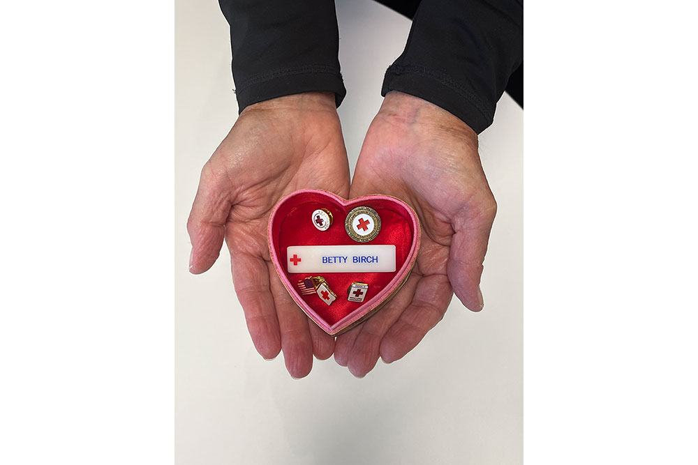 Red Cross service pins in a heart-shaped box.