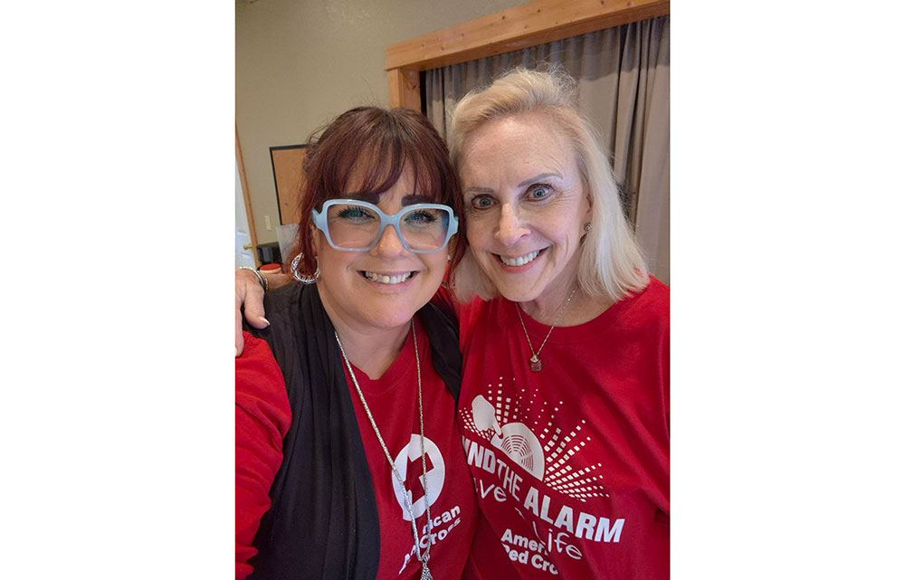Patti Duckworth and Elizabeth Gill in Red Cross shirts take a selfie.