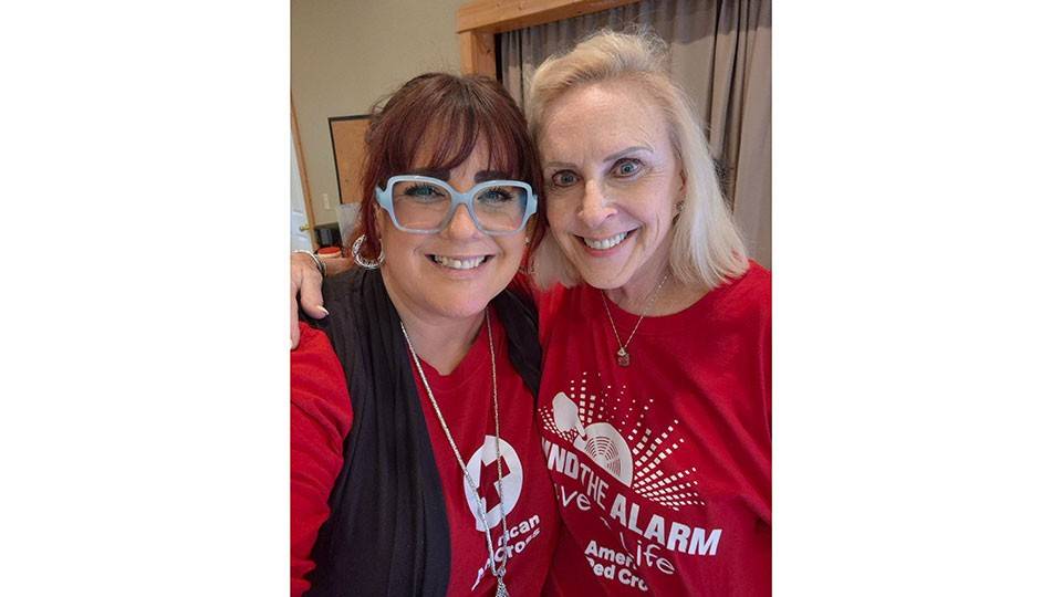 Patti Duckworth and Elizabeth Gill in Red Cross shirts take a selfie.