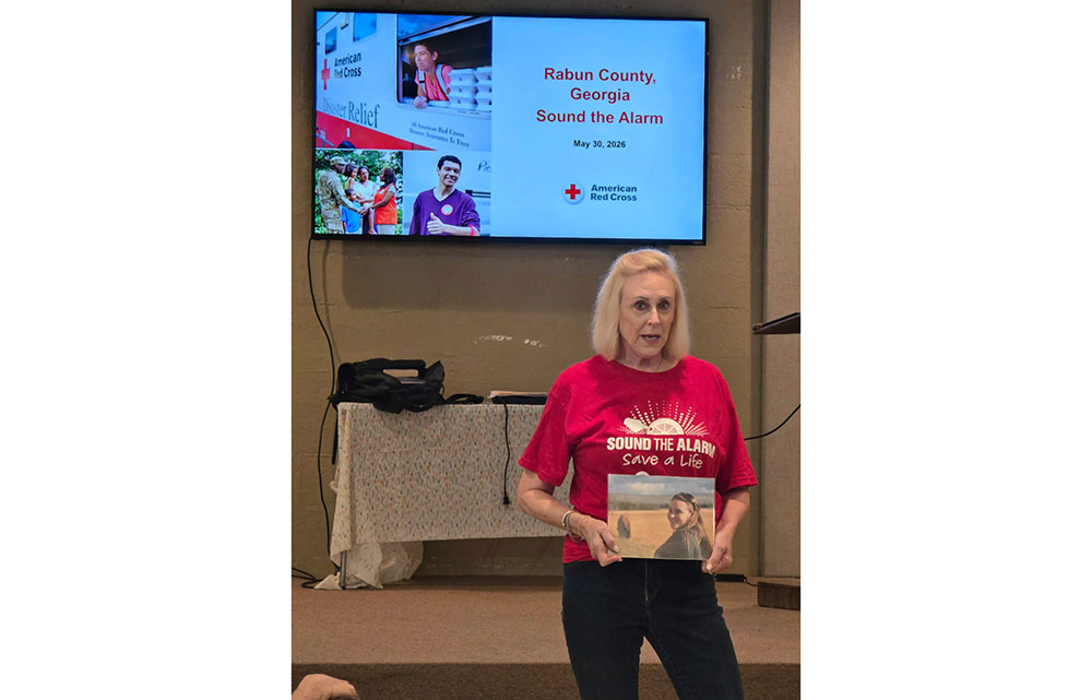 Elizabeth Gill speaking to the group while holding a picture of her daughter.