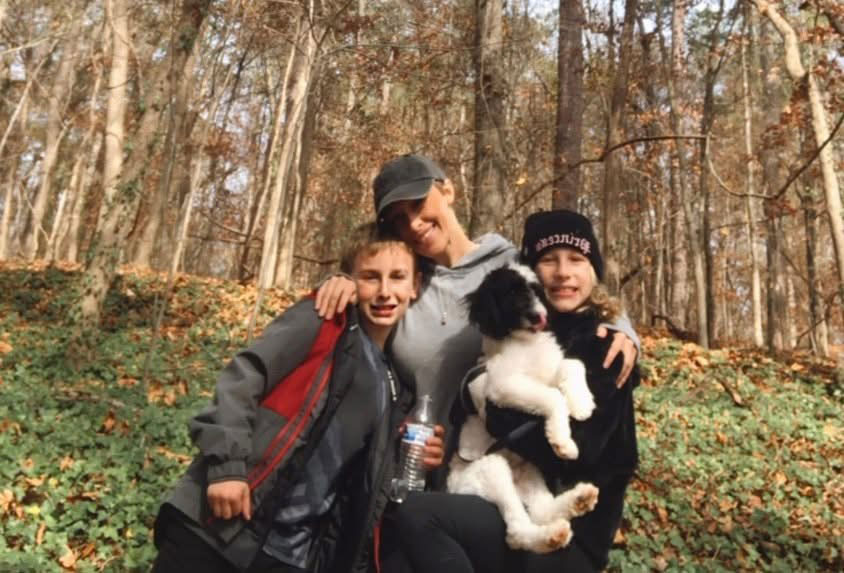 The Cook family: Cade, Ashley, Reilly and Bentley with a forest in the background.