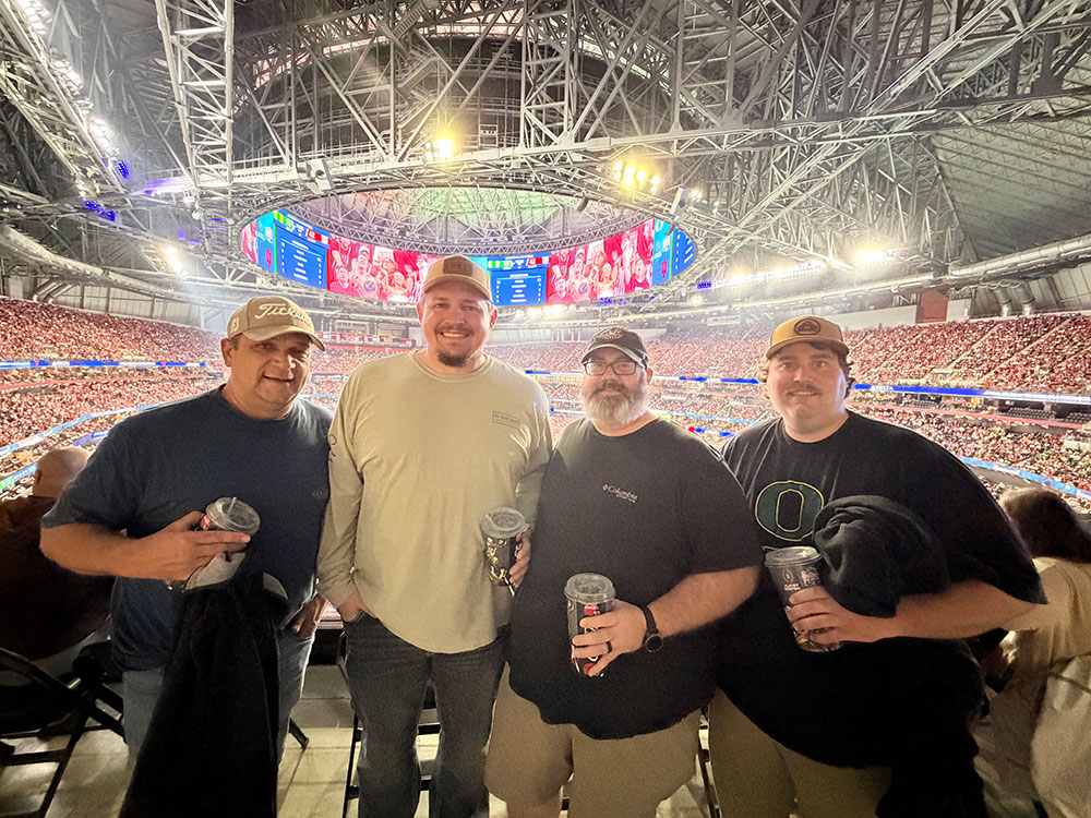 Kevin Kilgore with friends take a group picture together at the Peach Bowl.